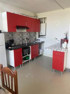 a kitchen with red cabinets and a sink at Red 4 x 4 in Camarma de Esteruelas