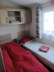 a small room with a bed and a window at Home from home Kingfisher caravan park in Skegness