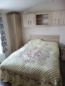 a bedroom with a bed with a quilt on it at Home from home Kingfisher caravan park in Skegness