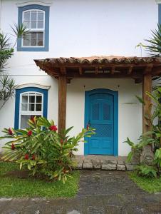 パラチにあるCasas dos Sonhosの青いドアとパーゴラのある家