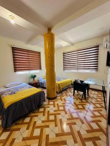 Un dormitorio con dos camas y una mesa dentro. en Hostal Shaddai, en Manta