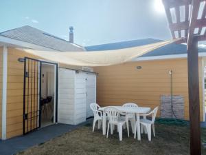 a patio with a table and chairs under awning at Petrel in La Paloma