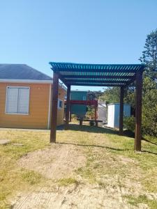 een pergola in een tuin naast een huis bij Petrel in La Paloma +11 foto's