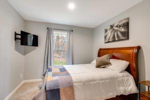 a bedroom with a bed and a tv and a window at White Mtns Holiday Home! Cabin 1 Mi to Skiing in Campton Upper Village +24 photos