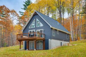 a black house on a hill in the woods at White Mtns Holiday Home! Cabin 1 Mi to Skiing in Campton Upper Village