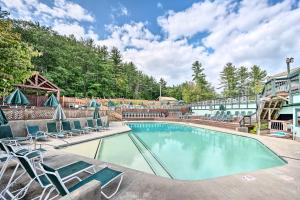 a swimming pool with lounge chairs and a building at White Mtns Holiday Home! Cabin 1 Mi to Skiing in Campton Upper Village