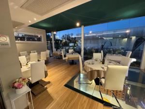a dining room with white tables and white chairs at Ristorante Locanda 7 Mari in Porto Viro
