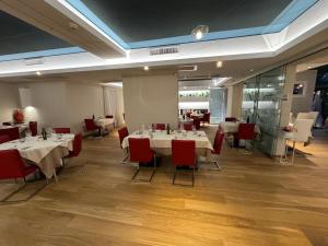 a dining room with white tables and red chairs at Ristorante Locanda 7 Mari in Porto Viro
