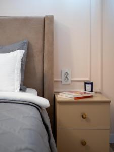 a bed with a nightstand next to a bed with a pillow at Seven Elite Apartments by Mega Mall in Almaty