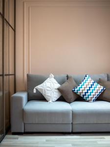 a couch with pillows on it in a living room at Seven Elite Apartments by Mega Mall in Almaty +119 photos