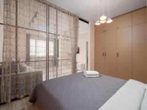a bedroom with a bed and a large window at Seven Elite Apartments by Mega Mall in Almaty