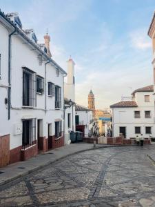 an empty street in a town with white houses at Casa Puerta de la Alcazaba Antequera in Antequera