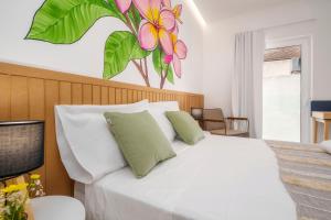 een slaapkamer met een wit bed en een bloemschilderij aan de muur bij Primavera House in Faro