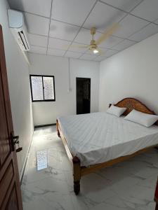 a bedroom with a large bed in a white room at Trikon Villaa in Trincomalee