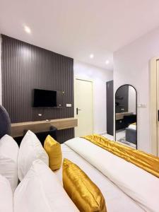 a hotel room with a large bed with gold pillows at UV Residence in Ikota
