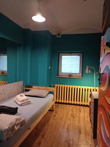 a bedroom with a bed and a radiator and a window at Jopi Hostel Katowice Centrum in Katowice