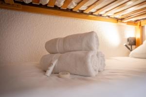 three towels stacked on top of a bed at Luxury 4BR Apartment with Fireplace & Private Parking - Val Thorens in Val Thorens
