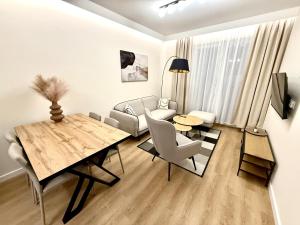 a living room with a dining table and a living room with a couch at Apartament Kaszmir in Kętrzyn +4 photos