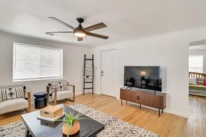 ein Wohnzimmer mit Deckenventilator und Fernseher in der Unterkunft Stylish Southwest Adobe Home in Old Town ABQ in Albuquerque