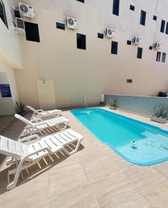 una piscina con tumbonas y una piscina en Pousada Praia Bela, en Maragogi