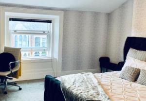 a bedroom with a bed and a chair and a window at Fairways guest house in Preston