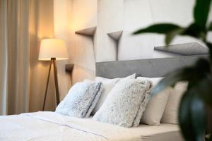 a bedroom with a bed with white pillows and a lamp at inJoy in Belgrade
