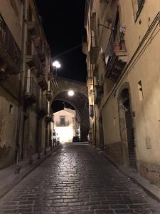 an alley way at night with a tunnel at Palazzo Sant'Elia in Caltagirone