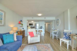 a living room with a blue couch and a kitchen at Verandas - 303 in Myrtle Beach