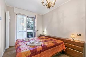 Un dormitorio con una cama y una ventana y una lámpara de araña. en Appartamento Il Palazzo - Happy Rentals, en Bardonecchia