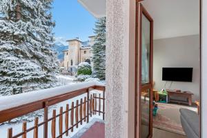 Un balcón con televisión y árboles cubiertos de nieve en Appartamento Il Palazzo - Happy Rentals, en Bardonecchia 22 fotos más