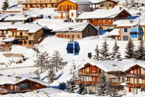 a village covered in snow with a ski lift at Appartamento Nido Alpino - Happy Rentals in Souchères Basses