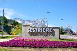 a sign for the olympics at a park with flowers at Appartamento Nido Alpino - Happy Rentals in Souchères Basses