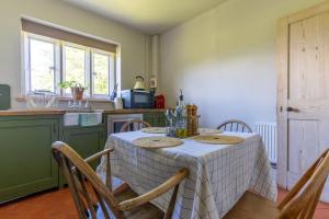 a kitchen with a table and chairs in a kitchen at The Coach House at Kingsettle Stud in Cholderton
