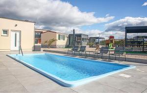 a swimming pool in a yard with chairs around it at Gorgeous Stacaravan In Drnis With Wifi in Brištane