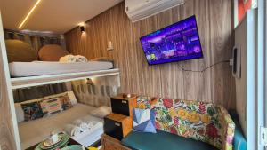 a room with a couch and a tv on a wall at Minicasa Brasileira in Sorocaba