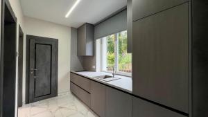 eine Küche mit Spüle und Fenster in der Unterkunft Sunny Beach in Saulkrasti