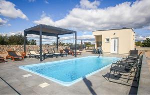 a swimming pool with chairs and a gazebo at Pet Friendly Stacaravan In Drnis With Wifi in Brištane