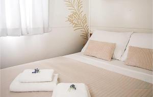 a bedroom with a bed with towels on it at Pet Friendly Stacaravan In Drnis With Wifi in Brištane