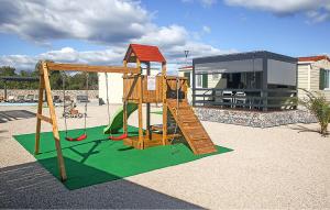 a playground with a slide and a swing at Pet Friendly Stacaravan In Drnis With Wifi in Brištane +7 photos
