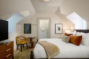 a bedroom with a large bed and a television at Dearborn Inn, Autograph Collection in Dearborn +111 photos