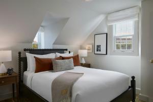 a bedroom with a large white bed and a window at Dearborn Inn, Autograph Collection in Dearborn