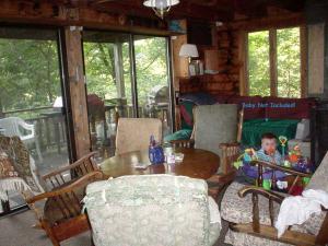 ein kleines Kind, das an einem Tisch in einer Hütte sitzt in der Unterkunft Spacious 14-Person Cabin Perfect for Families in Mount Holly, Vermont in Hortonville
