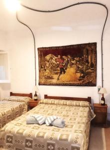 two beds in a bedroom with a painting on the wall at Hotel Medina y Mar BnB in Mar del Plata +64 photos