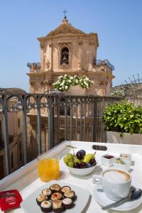 a table topped with a plate of food next to a window at Palazzo Conti Camere & Suites in Scicli