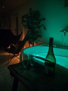 a bottle of wine and two glasses on a table at The other side of the CLT semi-detached house, with a separate SPA in Lahti +3 photos