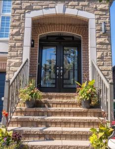 een voordeur van een huis met trappen en planten bij Peace Apartment in Brampton