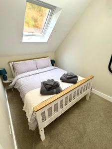 a bedroom with a bed with two towels on it at The Whitehouse in Pontypridd