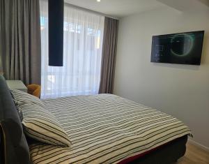 a bedroom with a bed with a tv on the wall at ZEN home in Chişinău