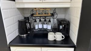 a small kitchen with bottles and mugs on a counter at A Star Living in Liversedge