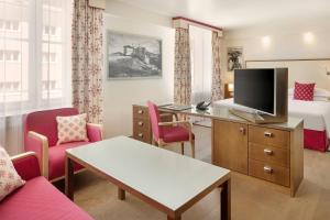 a hotel room with a bed and a television at Sheraton Grand Salzburg in Salzburg